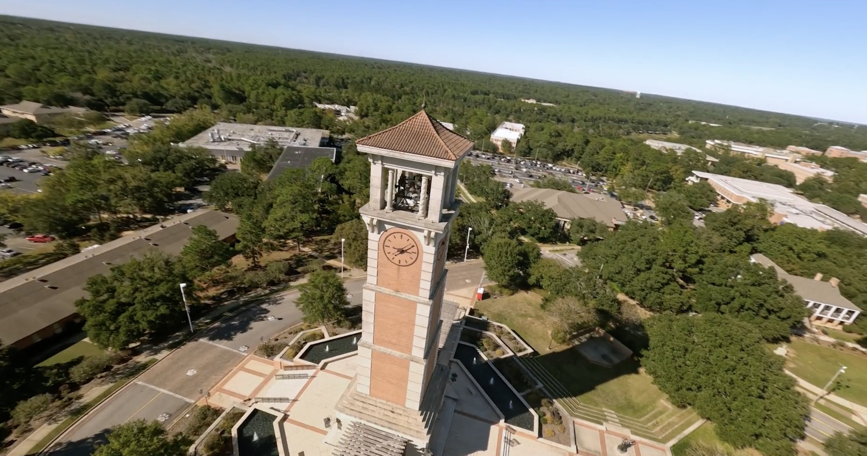 FPV aerial shot of university campus clock tower