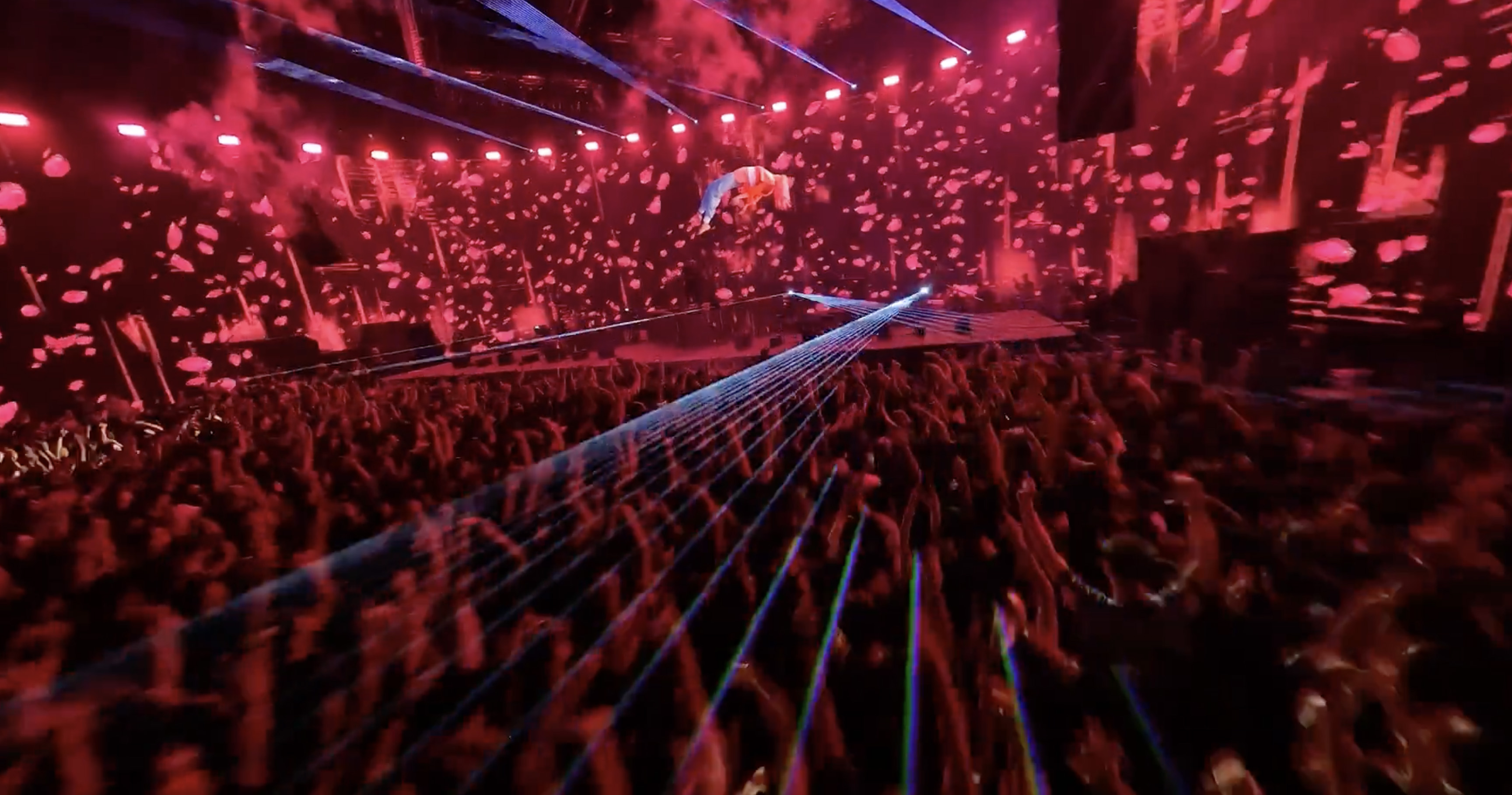 FPV drone shot over concert crowd with lasers and confetti